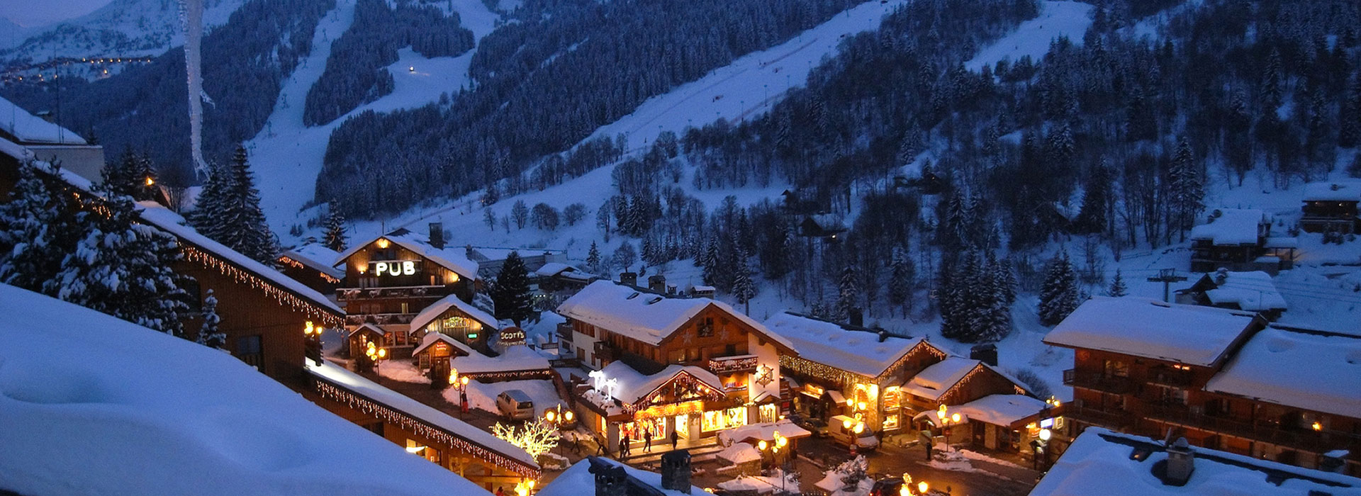 Vue de Méribel la nuit, chalets enneigés en Savoie